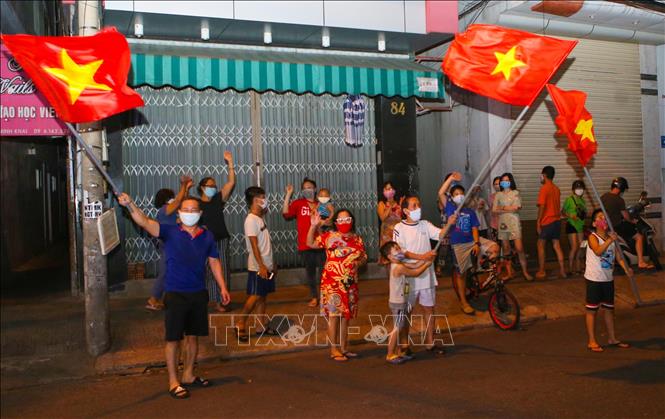 Người dân ở trên tuyến đường Nguyễn Thị Minh Khai vui mừng sau khi hoàn thành cách ly 14 ngày trong khu vực phong tỏa. Ảnh: Trần Lê Lâm/TTXVN