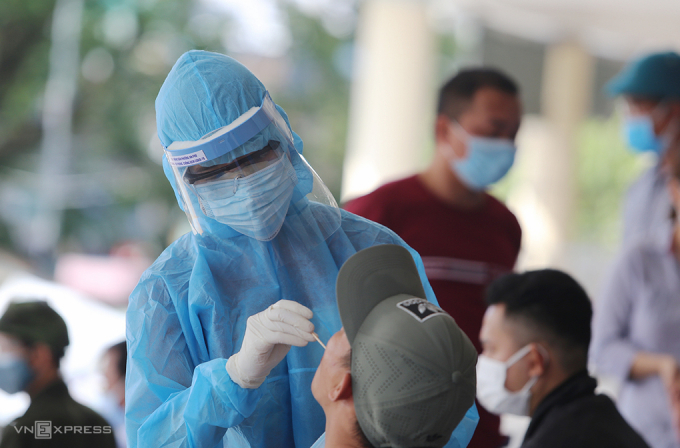 Nhân viên y tế Quảng Nam lấy mẫu xét nghiệm người đi từ Đà Nẵng về. Ảnh: Đắc Thành.