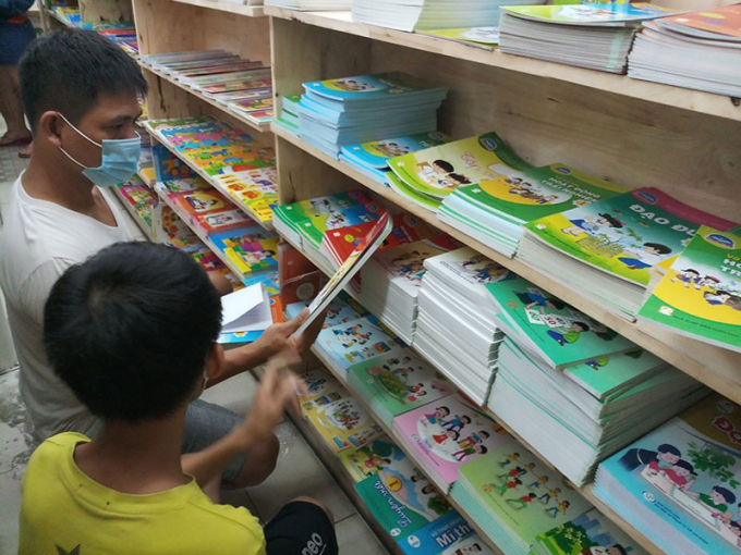 Phụ huynh tìm mua sách lớp 1 cho con tại nhà sách Phan Huy Ích, quận Gò Vấp. Ảnh: NGUYỄN QUYÊN