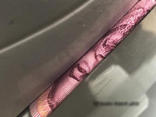 Số tiền được kẹp cẩn thận ở mép của cốp xe.