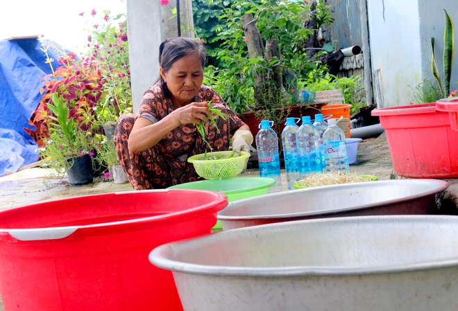 Không có nước sạch, người dân phải đi xin hoặc mua từng bình nước về dùng. Ảnh: A. Bình.