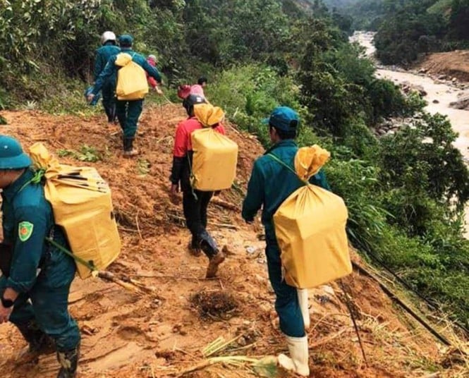 Lực lượng Huyện đội Phước Sơn bất chấp nguy hiểm băng rừng cõng lương thực vào tiếp tế cho đồng bào đang bị cô lập ở Phước Lộc, Phước Thành - ảnh T.N