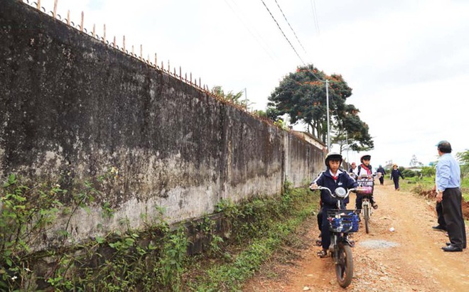 Học sinh và người dân thường xuyên lưu thông trên con đường cạnh tường rào của trường. Ảnh: Tiền Phong.