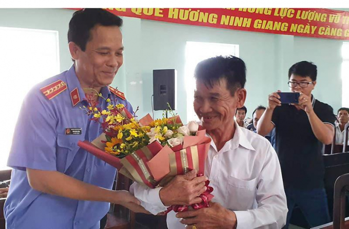 Ông Trần Đình Hồng, Viện phó VKSND tỉnh Khánh Hòa, tặng hoa ông Trần Bê sau khi xin lỗi hồi tháng 9-2029. Ảnh: TẤN LỘC