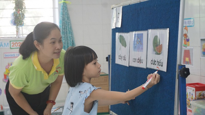 Cô Nguyễn Thanh Thủy, giáo viên trường Mầm non Tuổi Thơ 7, quận 3 hướng dẫn trẻ làm quen với chữ 