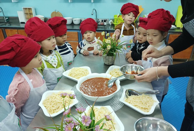 Trẻ mẫu giáo Trường mầm non Thực hành Linh Ðàm (Hà Nội) trong một giờ học làm món mỳ Ý