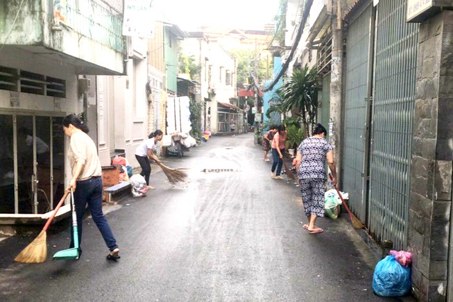 Người dân hẻm 80 Dương Quảng Hàm, khu phố 14, phường 5, quận Gò Vấp đang dọn vệ sinh trong khu vực. Ảnh: VÕ HÀ