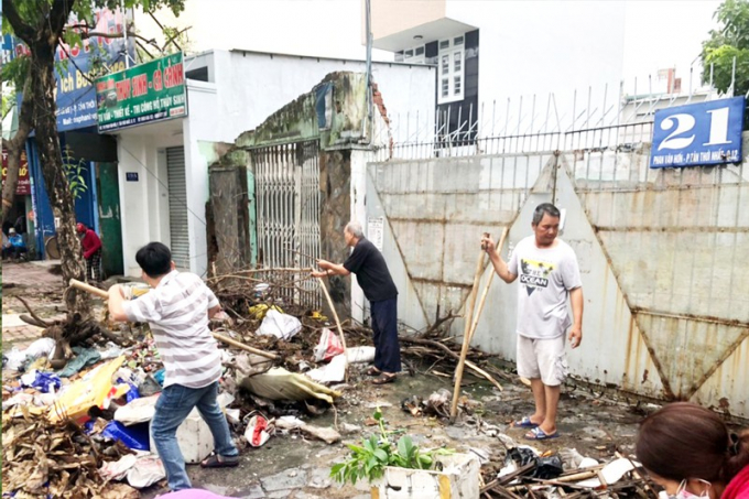 Người dân đang dọn vệ sinh trên đường Phan Văn Hớn, phường Tân Thới Nhất, quận 12. Ảnh: VÕ HÀ