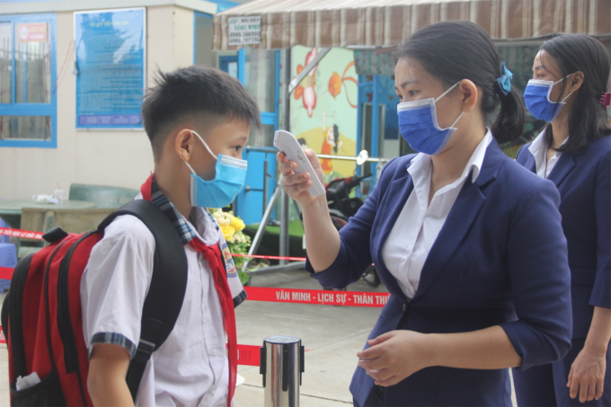 Học sinh Trường Tiểu học Lê Đức Thọ, Quận Gò Vấp kiểm tra thân nhiệt trước khi vào trường.