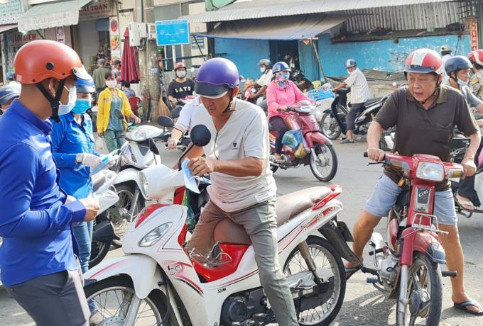 Lực lượng phòng, chống dịch Covid-19 tại TP Sóc Trăng phát khẩu trang cho người dân tại chợ trung tâm TP Sóc Trăng. Ảnh: Việt Tường.