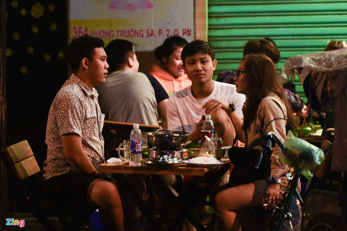 Ngoài quán nhậu, nhiều quán cà phê cũng rất đông khách. Một nhóm khách tụ tập, nói chuyện trên vỉa hè ở một quán cà phê trên đường Quách Thị Trang (quận 1) lúc 0h.