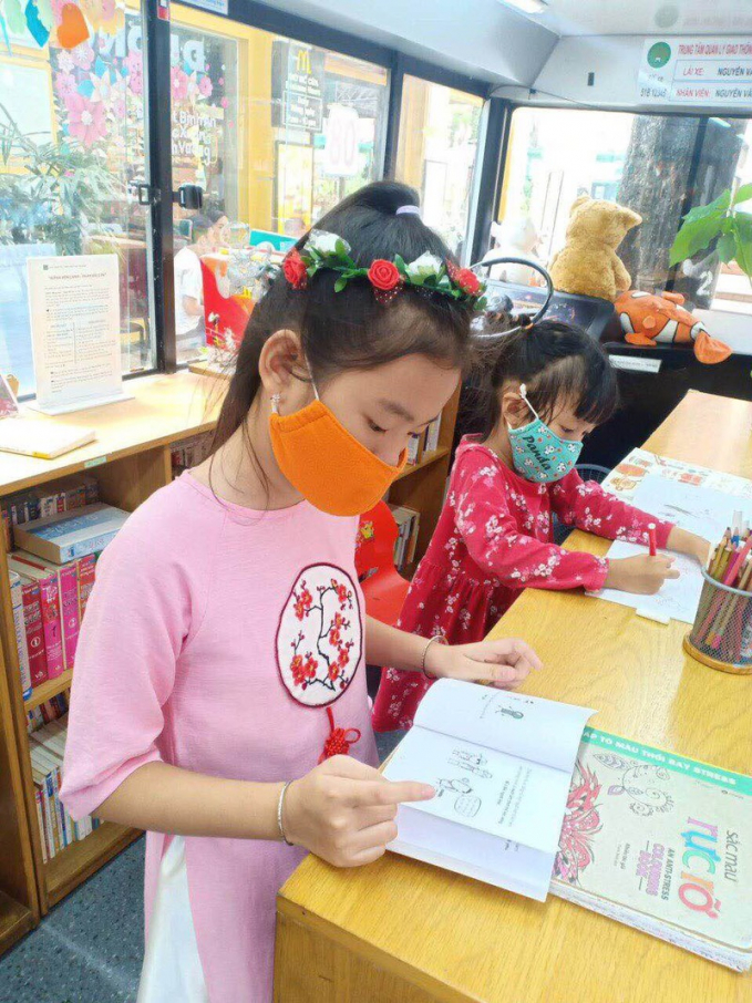 Các em nhỏ thích thú với xe bus sách “Chuyến xe chở tri thức – chở tương lai” thư viện mini tại Đường Sách phục vụ xuyên Tết.