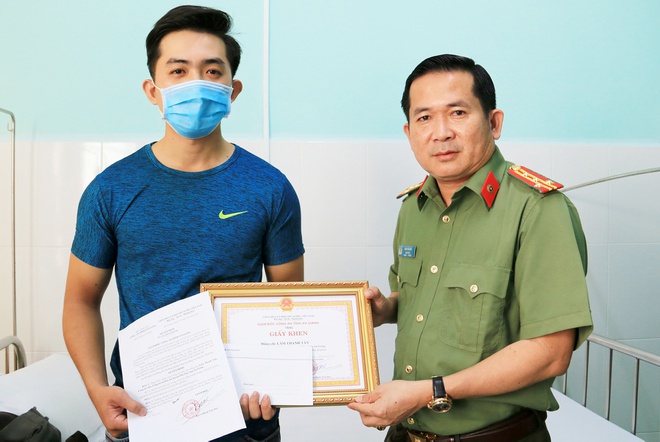 Đại tá Đinh Văn Nơi, Giám đốc Công an tỉnh An Giang tặng giấy khen cho anh Lâm Thanh Tân. Ảnh: Nghiêm Túc.