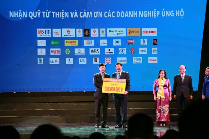 Ông Vũ Văn Hậu - em trai ông Vũ Văn Tiền (trái) trao tiền ủng hộ tại một sự kiện.