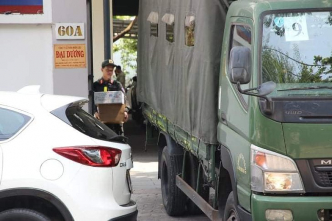 Cảnh sát cơ động chuyển các thùng tài liệu thu giữ trong công ty ra xe tải. Ảnh: T.SANG