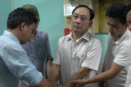 Cảnh sát thực hiện lệnh bắt giữ ông Nguyễn Văn Ngưu (đứng giữa). Ảnh: Lê Hoài