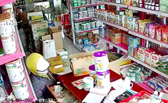 Camera ghi lại cảnh người phụ nữ trộm tiền trong cửa hàng bách hóa. Ảnh: cắt từ clip.