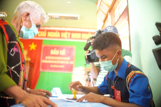 Cán bộ hướng dẫn cử tri tham gia bỏ phiếu tại làng Cát, xã Canh Liên, huyện Vân Canh, Bình Định