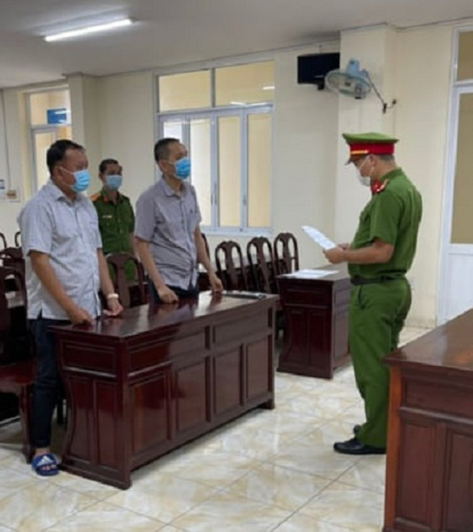 Công an đọc Quyết định khởi tố bị can, Lệnh cấm đi khỏi nơi cư trú đối với bị can Lê Dương Sơn Minh và bị can Lê Dương Sĩ Mẫn. Ảnh: VH