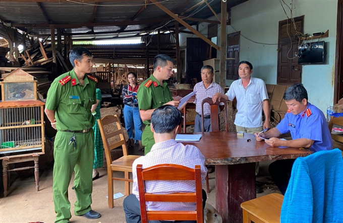 Nguyễn Quốc Hùng (áo sơmi trắng), thời điểm nghe lực lượng Công an đọc quyết định bắt.