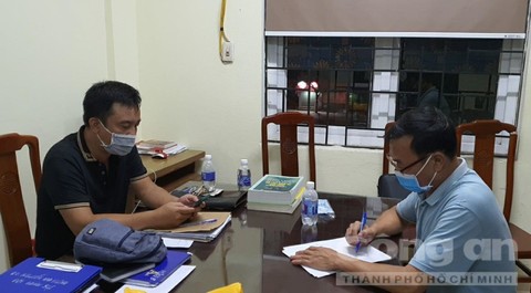 Điều tra viên (trái) làm việc với đối tượng Đỗ Văn Bình