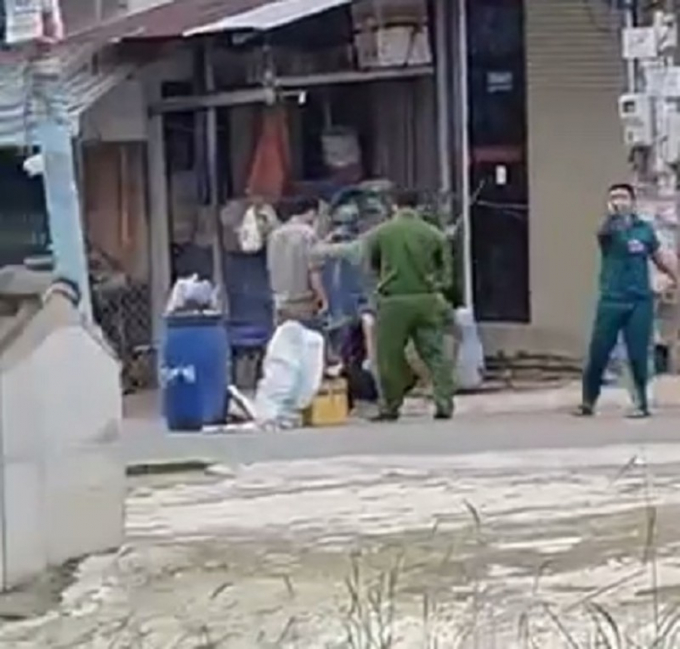 Mặc dù xuất hiện người mặc áo cảnh sát nhưng nhóm dân phòng, dân quân vẫn đánh người dân. Ảnh: Cắt từ Clip.