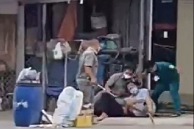 Nhóm người mặc áo dân quân, dân phòng đánh rất dã man. Ảnh: Cắt từ Clip.