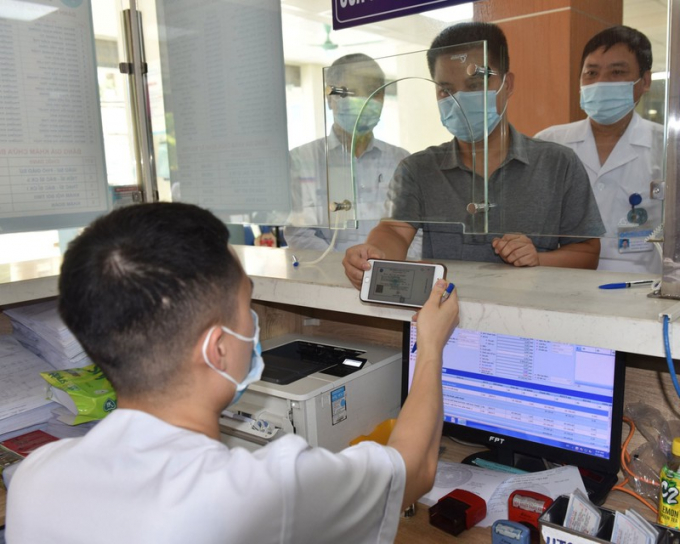 Người dân sử dụng thẻ bảo hiểm y tế trên ứng dụng VssID để đi khám bệnh. Ảnh: V.LONG