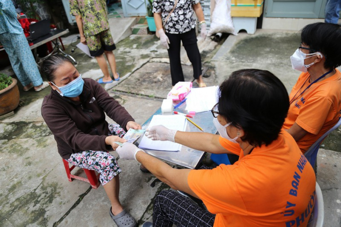 Người dân khu phố 1 phường 5, quận Phú Nhuận, TP.HCM nhận hỗ trợ đợt 3. Ảnh: HOÀNG GIANG
