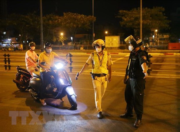 Tổ công tác của Đội Cảnh sát giao thông Chợ Lớn kiểm tra hành chính một người điều khiển xe máy. (Ảnh: Thành Chung/TTXVN)