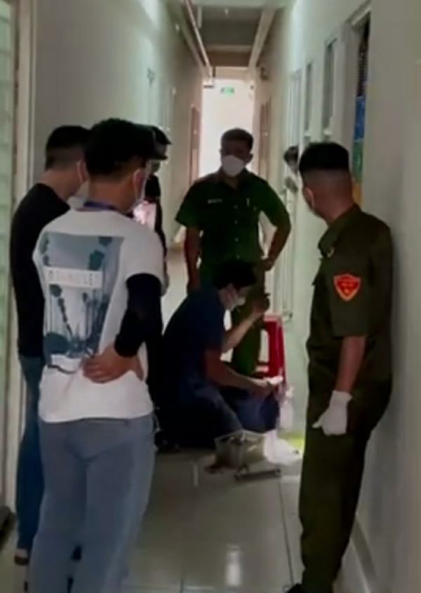 Hình ảnh phía trước cửa căn hộ của bà H.T.P.L, một người đàn ông đang tiến hành mở khóa cửa.