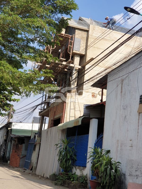 Thợ thi công nhà đang hàn xà gồ thuộc phần mái của căn nhà