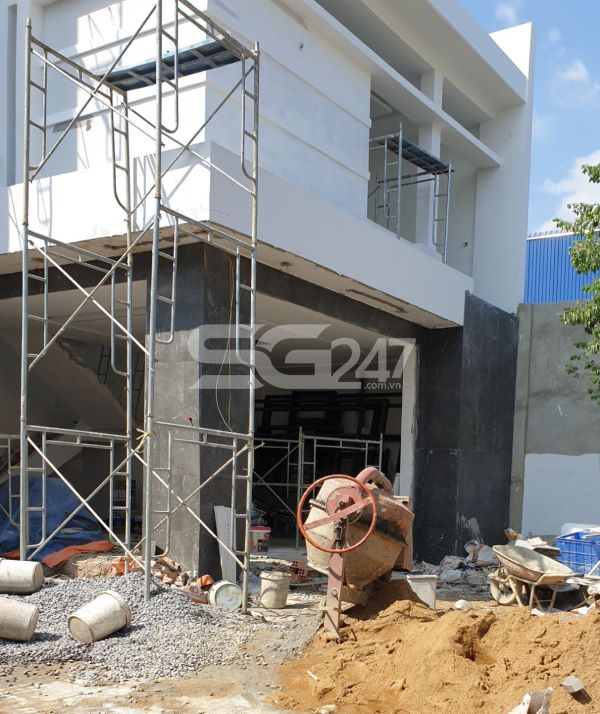 Ngổn ngang vật liệu xây dựng, công cụ sử dụng cho việc xây dựng nằm trên đất.