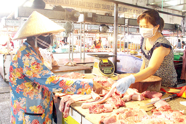 Giá thịt heo liên tục biến động trong khoảng hơn nửa tháng trở lại đây. Trong ảnh: Người dân chọn mua thịt heo tại chợ Hóa An (TP.Biên Hòa)