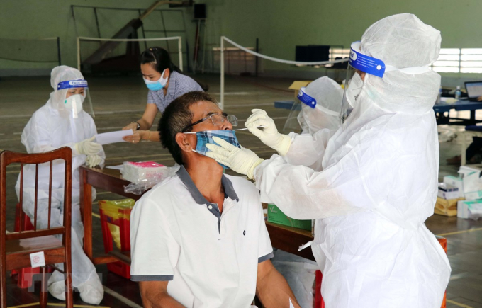 Nhân viên y tế xét nghiệm SARS-CoV-2 bằng kỹ thuật test nhanh kháng nguyên. (Ảnh: Công Thử/TTXVN)