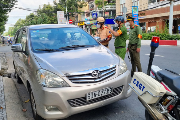 Lực lượng chức năng yêu cầu xuống xe làm việc nhưng ông Chính đóng cửa, cố thủ trong xe. Ảnh: B.A./Tuổi Trẻ Online