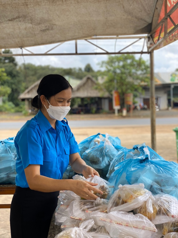 Bí thư huyện Đoàn Bù Đăng Đào Thị Quế đang sắp xếp các phần thức ăn đượm yêu thương để gửi đến đồng bào về quê tránh dịch đi ngang qua địa phương