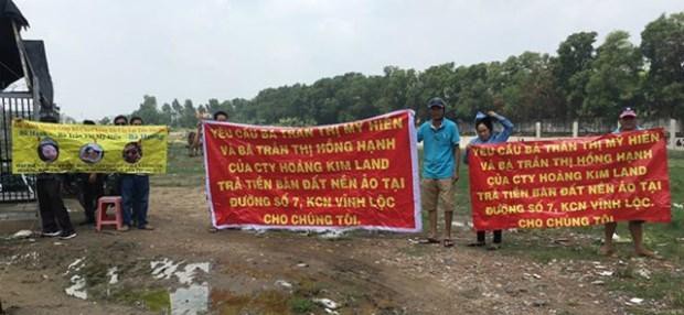 Nạn nhân căng băng rôn để tố cáo nhóm của bà Trần Thị Mỹ Hiền, Trần Thị Hồng Hạnh lừa đảo, chiếm đoạt tiền. (Nguồn: CAND)