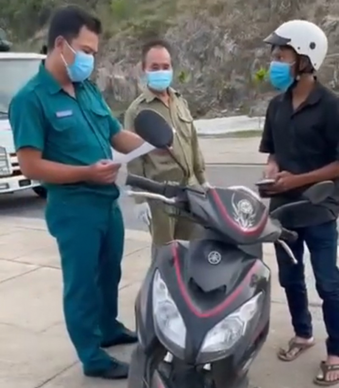 Lực lượng liên ngành phường Vĩnh Hòa kiểm tra, tạm giữ giấy tờ của anh Trần Văn Em. Ảnh cắt từ clip.