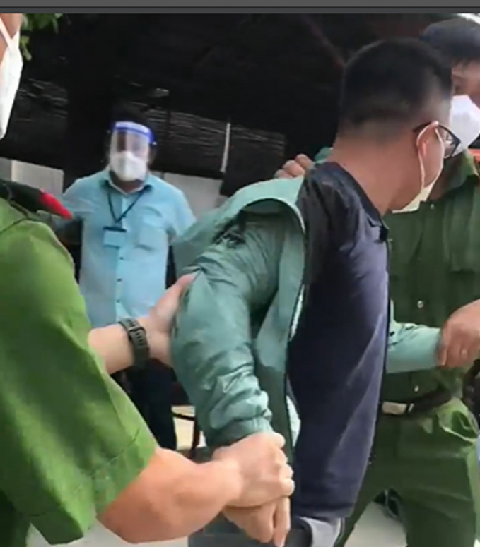Ông T. bị công an dẫn đi. Ảnh cắt từ video