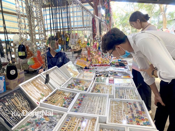 Khu du lịch núi Chứa Chan là một trong những điểm đến bán nhiều mặt hàng lưu niệm hai bên đường lên núi. Trong ảnh: Khách mua sản phẩm lưu niệm tại Khu du lịch núi Chứa Chan. Ảnh: Thủy Mộc
