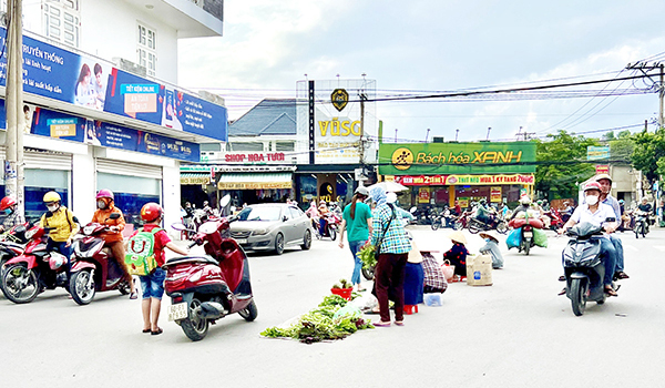 Giao lộ Nguyễn Phúc Chu - Trần Văn Xã lâu nay vẫn còn tồn tại tình trạng người buôn bán hàng rong bày hàng ngay giữa giao lộ, nguy hiểm cho người và phương tiện đi qua đây