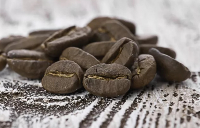 Hạt cà phê phủ socola trên bàn gỗ. (Ảnh: iStock)