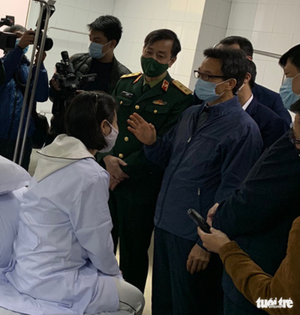 Phó thủ tướng Vũ Đức Đam trò chuyện với 1 trong 3 tình nguyện viên đầu tiên tiêm thử nghiệm vắc xin - Ảnh: L.ANH