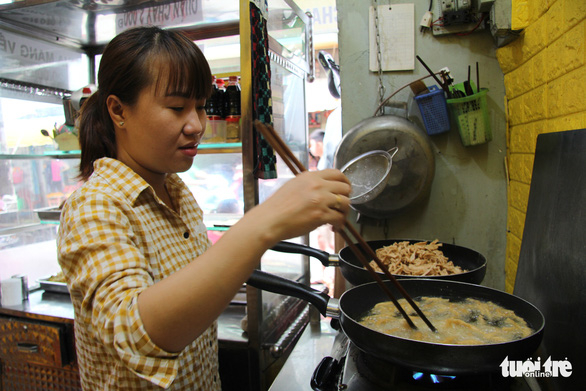 Chị Vương Kim Long, chủ quán cơm chay Tùy Tâm, chuẩn bị cho bữa cơm trưa - Ảnh: KIỀU HẠNH