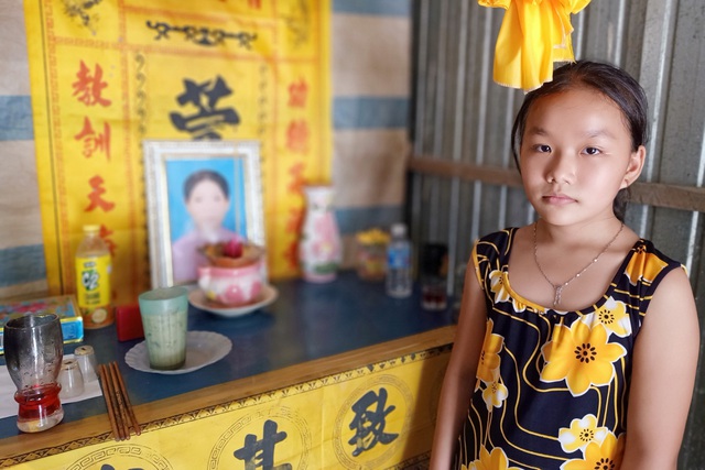 Bé Huỳnh Ngọc Trang bên bàn thờ mẹ. Cha bỏ rơi khi em sinh ra chưa đầy tháng. Lên 10 tuổi, mẹ cũng bỏ em mà đi vì bệnh hiểm nghèo.