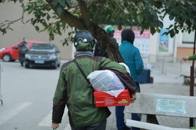 Ngay từ sáng sớm, nhiều phụ huynh có mặt tại cổng trường để tiếp tế đồ ăn, nước uống, quần áo cho học sinh. (Ảnh: B.L)