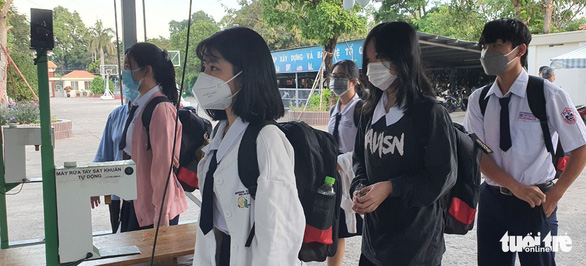 Học sinh Trường THPT Phú Nhuận xếp hàng đo thân nhiệt tự động trước khi vào trường - Ảnh: H.HG.