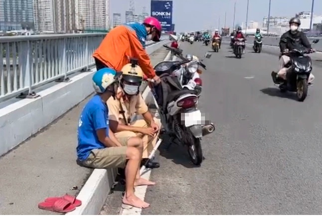 CSGT khuyên người đàn ông từ bỏ ý định nhảy cầu. Ảnh: N.A.