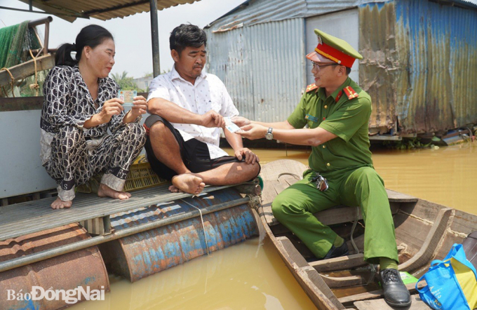 Cán bộ chiến sĩ Công an P.Long Bình Tân phát thẻ CCCD cho người dân tại làng bè KP.Thái Hòa. Ảnh: Công an cung cấp